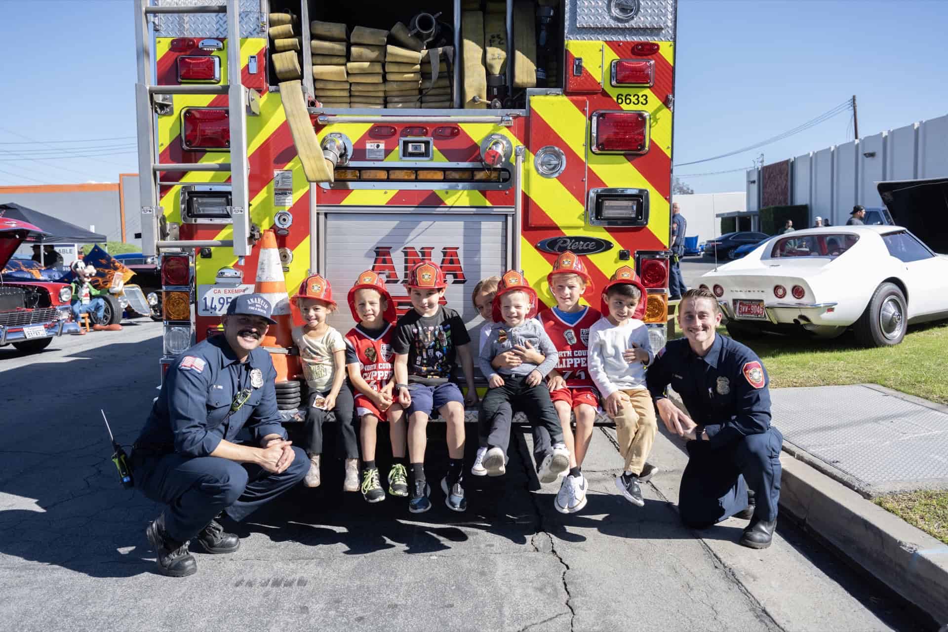 Firefighters with children sitting on a fire truck at Highway 39 Event Center.